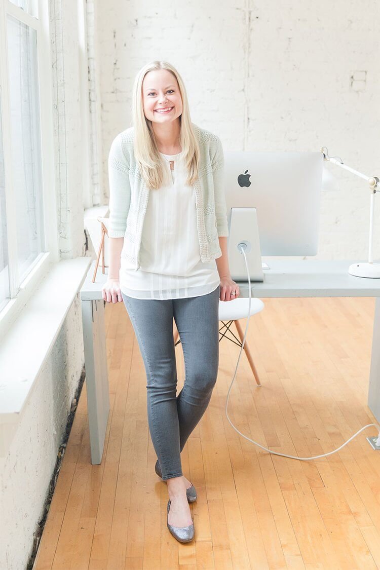 Duett Client - Sara Dunn of Sara Does SEO- Smiling at the camera leaning against a desk